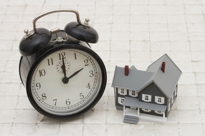 50529960 - time to buy a house, a gray house and black alarm clock on stone background